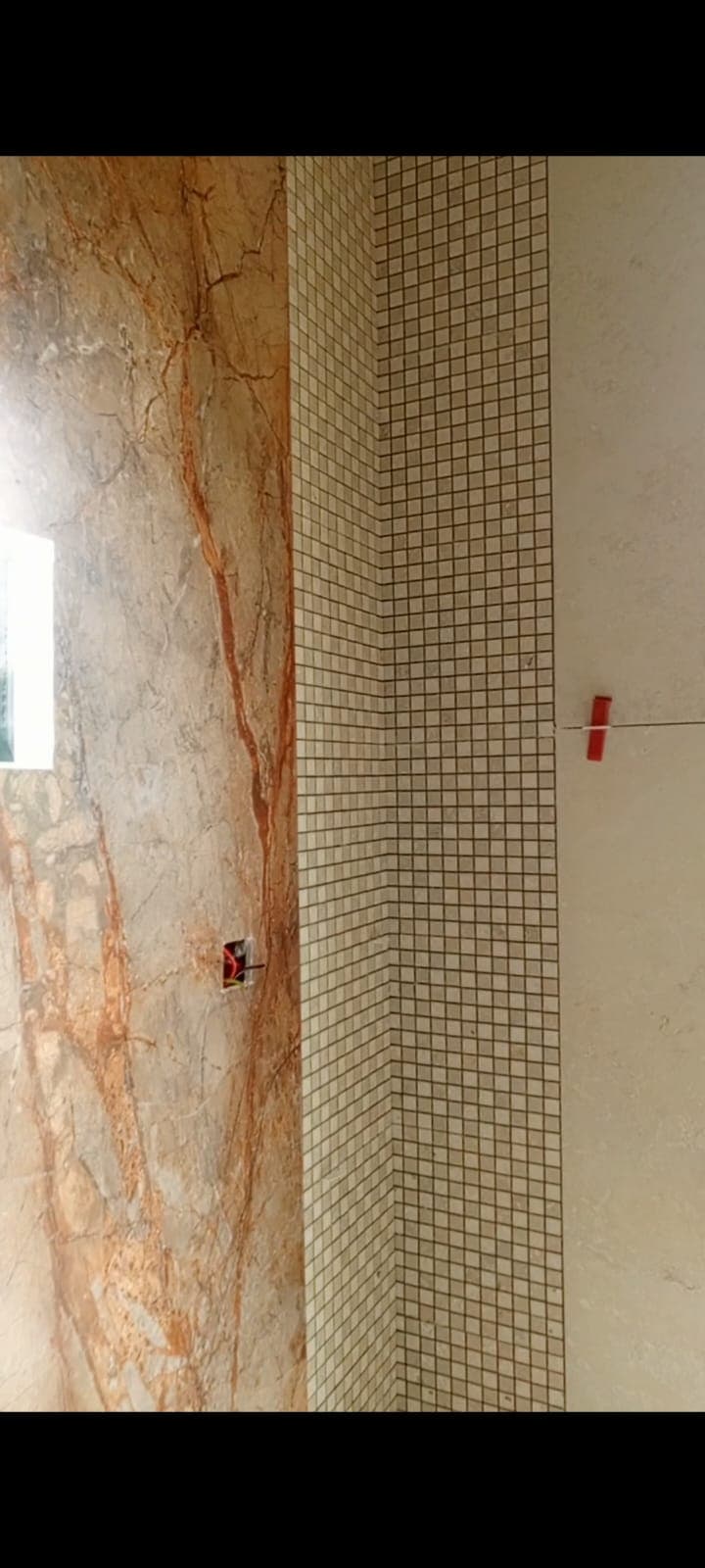 Mosaic-tiled pier meeting the vein-matched feature slab and cream wall tile, Askari 10 bathroom, Islamabad