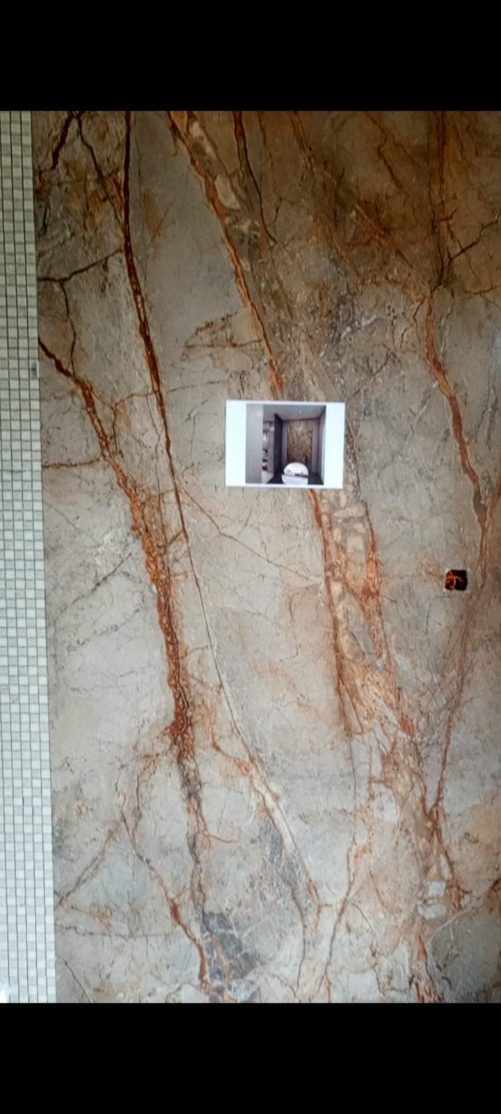 Close-up of the brown vein-matched marble-look feature slab with the design reference taped to it, Askari 10 bathroom, Islamabad
