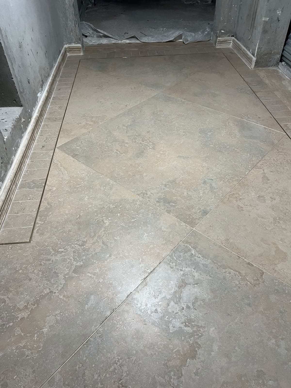 Corridor floor featuring diamond-pattern large-format porcelain tiles framed with border inlays and stone skirting in Askari 10, Islamabad