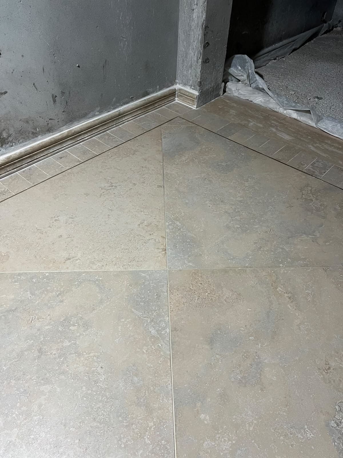Intersection where 45-degree diagonal floor tiles meet the perimeter border and skirting moulding at a corridor corner, Askari 10