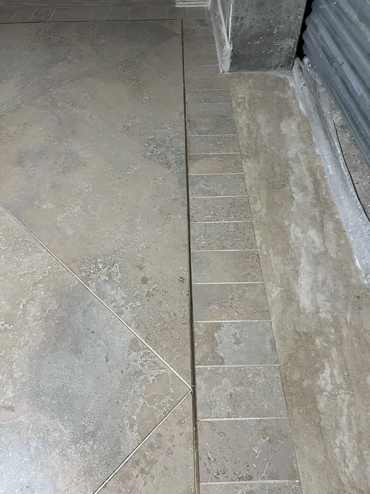 Detailed border transition featuring diagonal porcelain floor tile, metallic inlay strip, and stacked border tiles in Askari 10