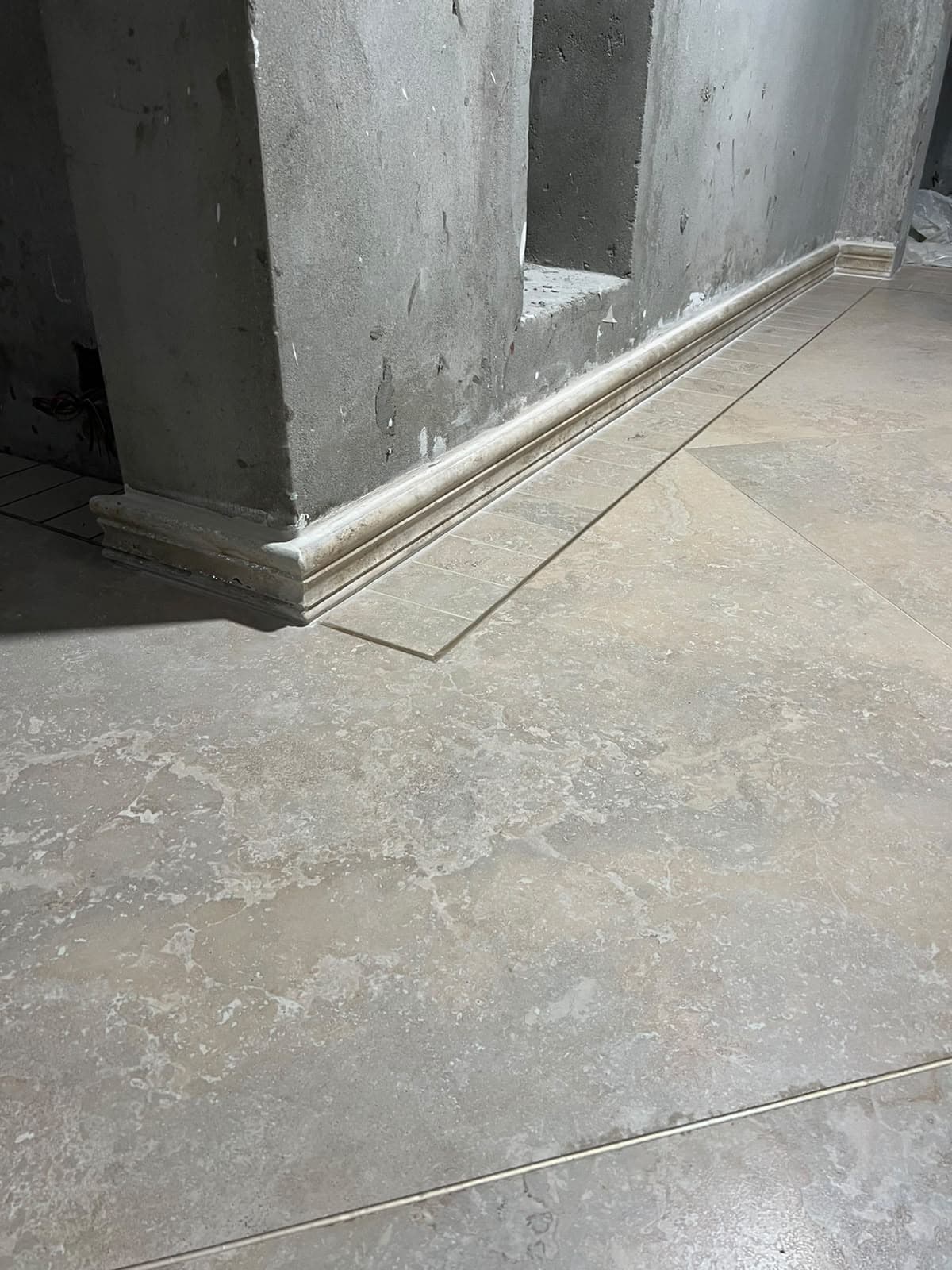 Continuous stone skirting moulding and rectangular tile border along the corridor wall in Askari 10, Islamabad