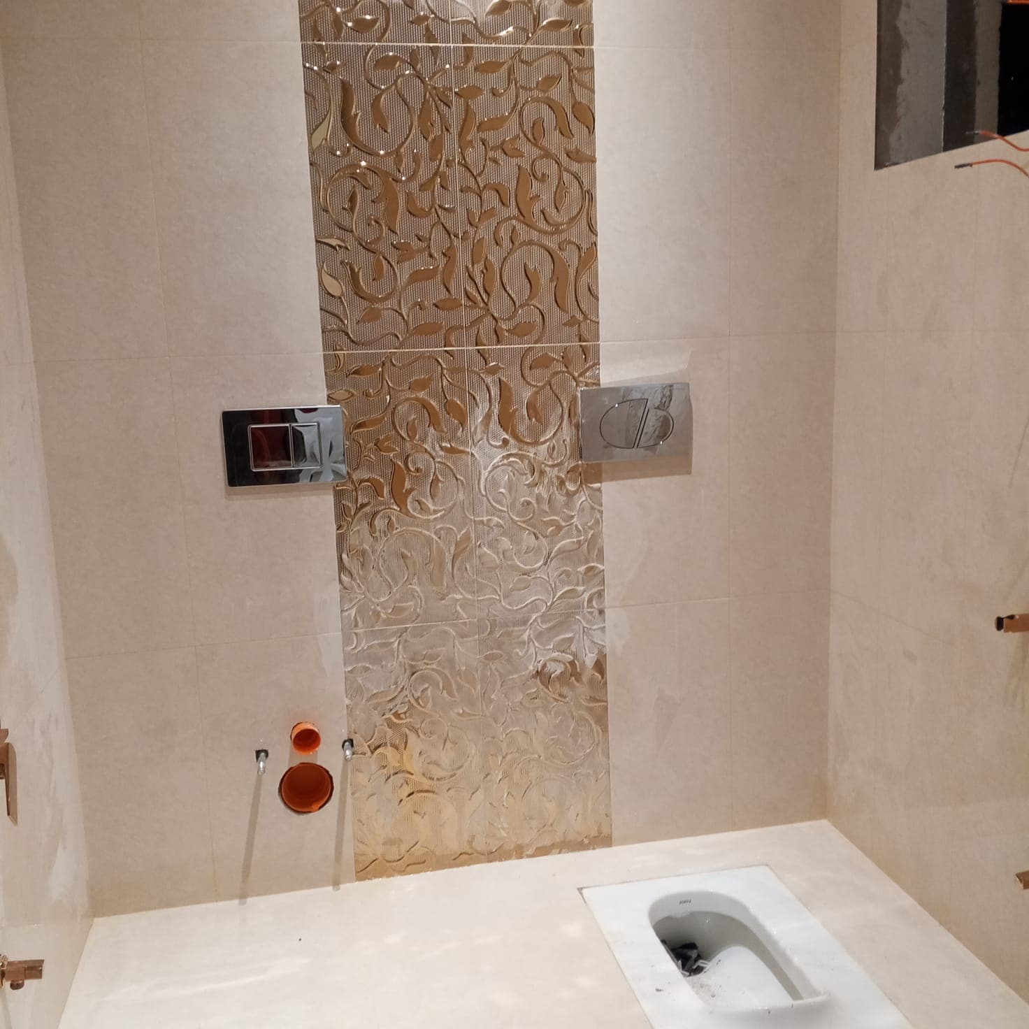 Luxury bathroom wall and floor tiling completed with gold relief decorative feature band and wall-hung sanitary fittings in F-6 / F-7 Islamabad