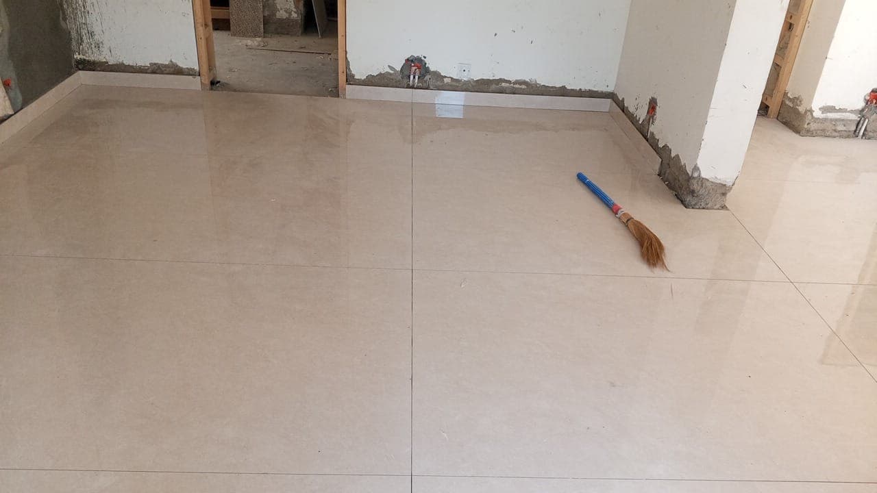 Freshly fixed large-format porcelain floor tiles and perimeter skirting during residential construction in F-6 / F-7 Islamabad