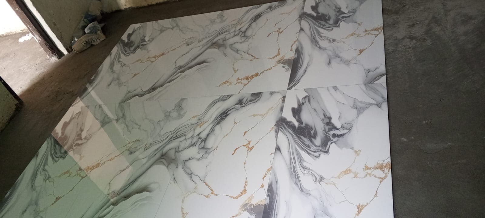 Four-slab bookmatched porcelain floor dry-lay verification before final adhesive fixing in F-6 / F-7 Islamabad