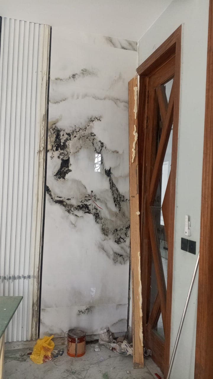 Large-format mountain-vein marble porcelain slab wall installation framing an interior doorway in F-6 / F-7 Islamabad