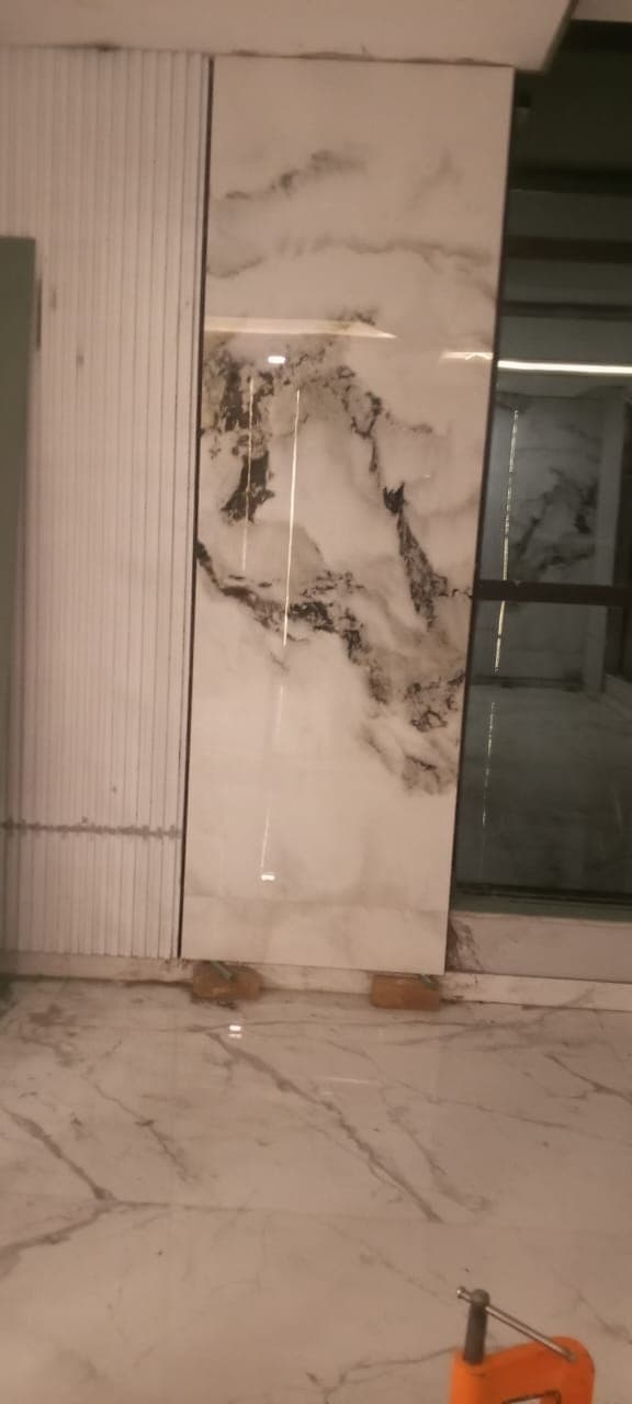 Floor-to-ceiling marble porcelain slab feature panel aligned with fluted wall panel and door casing in F-6 / F-7 Islamabad