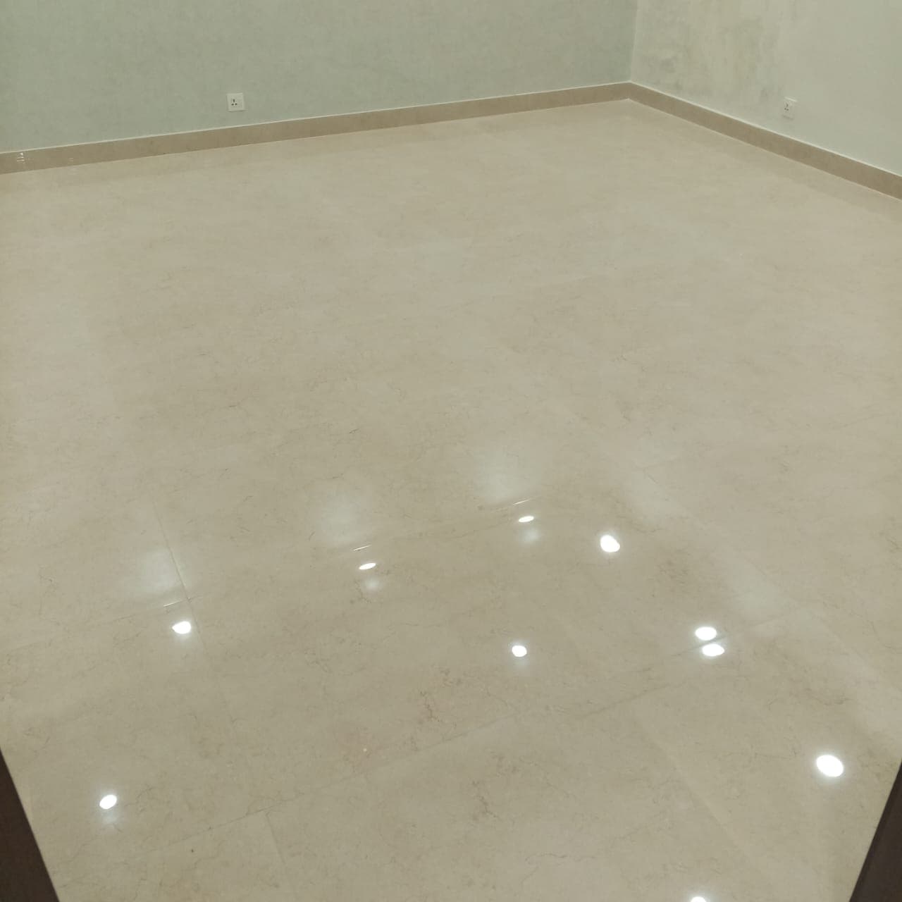 Finished mirror-finish porcelain floor tiles with matching perimeter skirting in a newly tiled room in F-6 / F-7 Islamabad