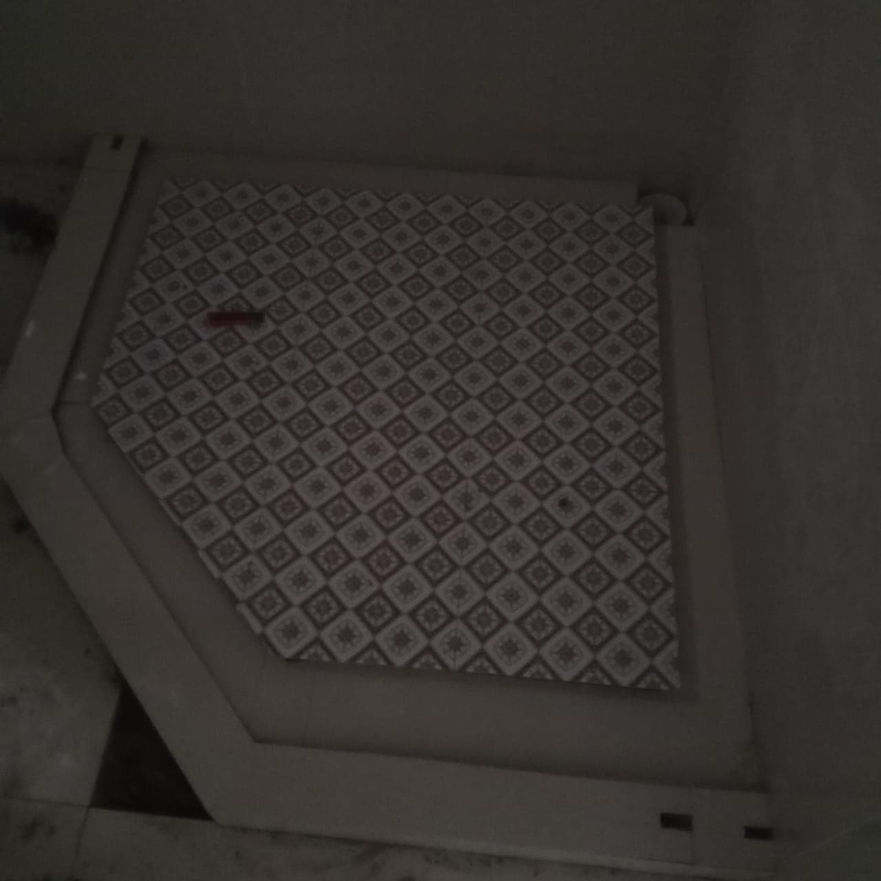 Angled shower pan floor with geometric tile pattern inlay and perimeter curb in F-6 / F-7 Islamabad