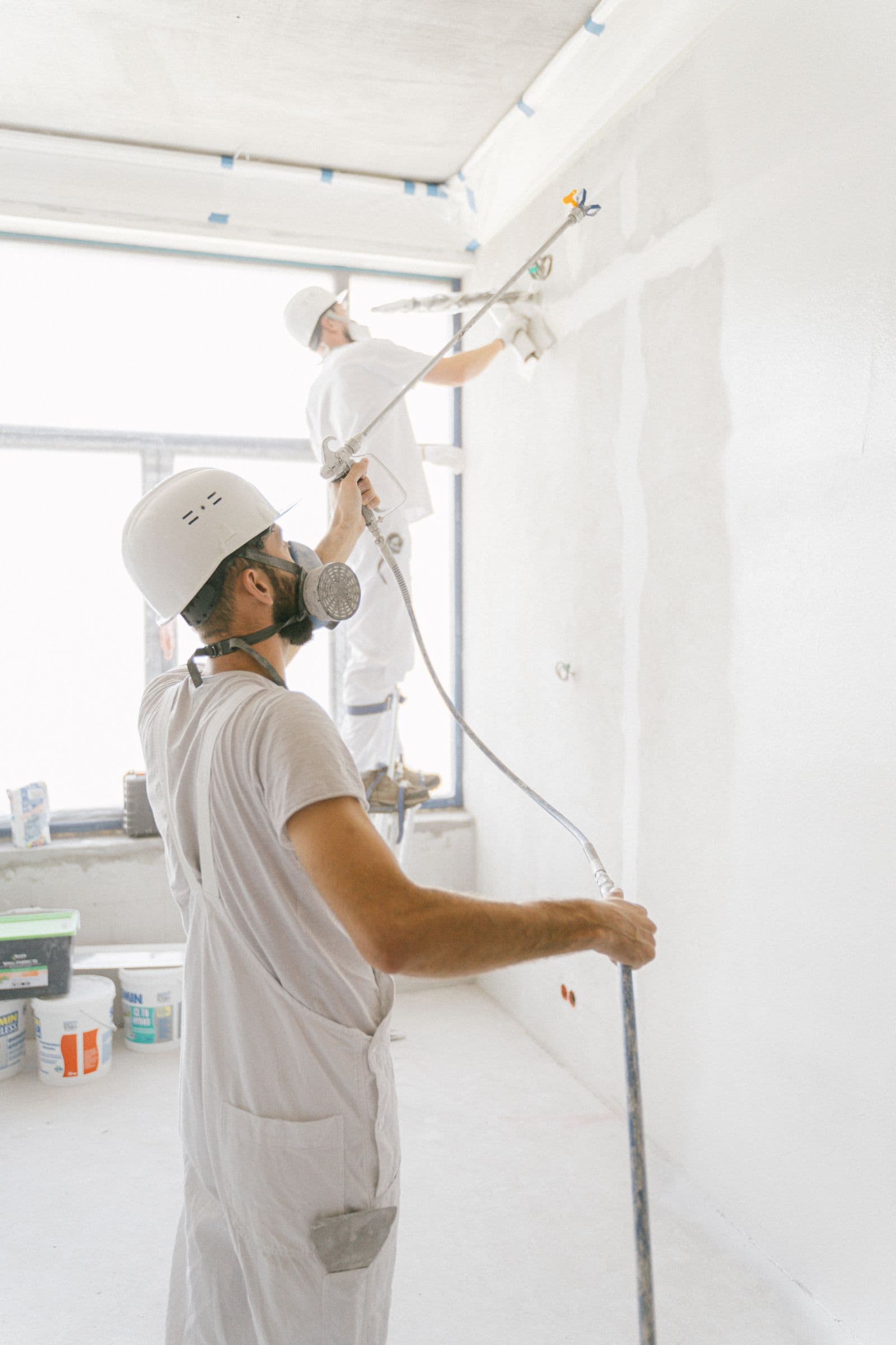 Professional painters preparing and painting an interior wall