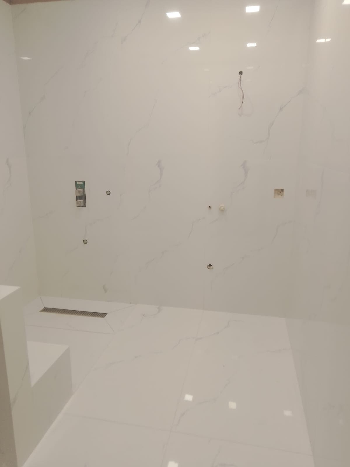 Master bathroom finished in book-matched Calacatta porcelain slabs with a floating vanity, Clifton Karachi