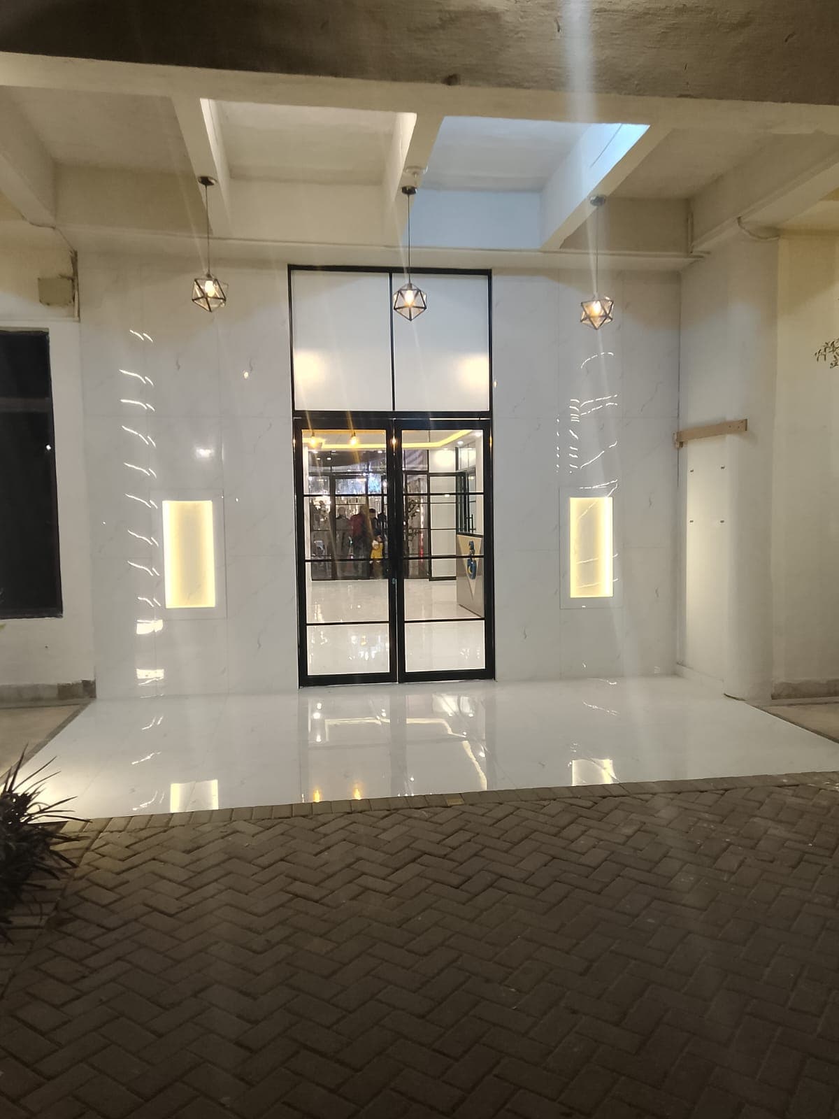 Glass entrance portal and marble-look floor of a Gulberg Lahore showroom