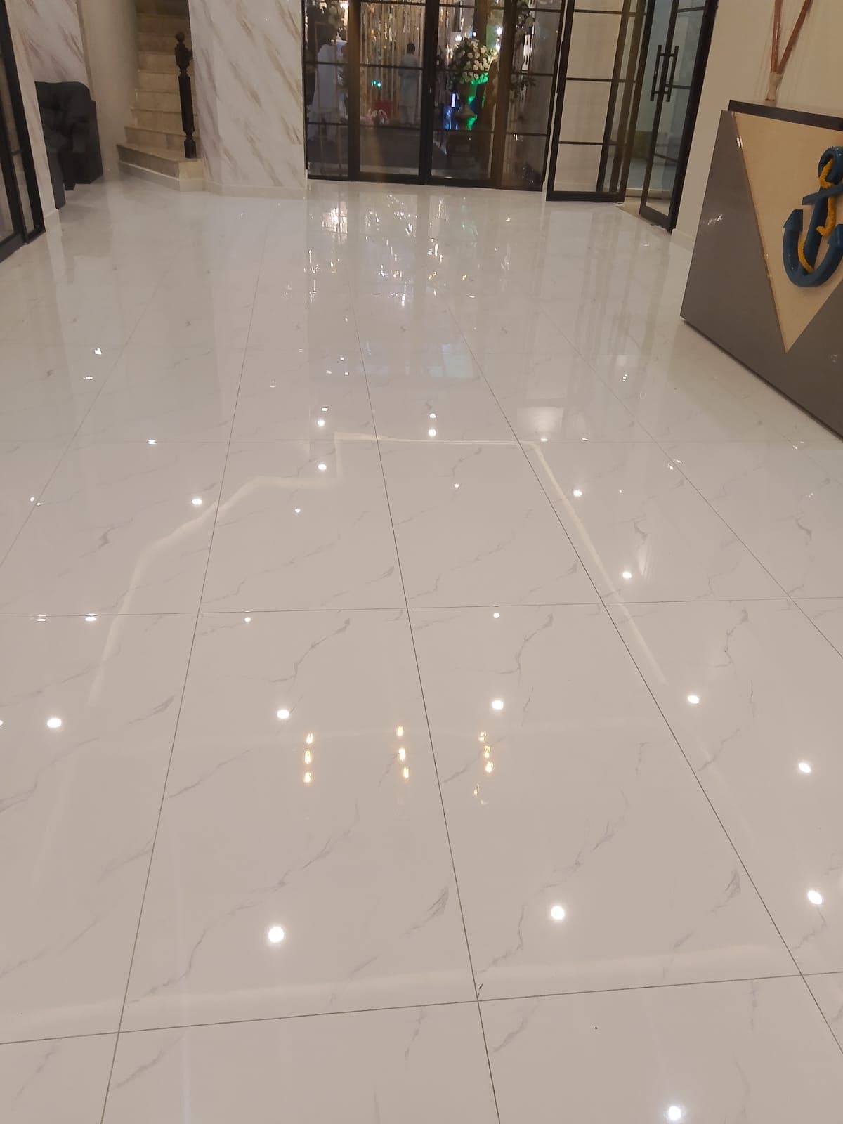 Polished marble-look porcelain floor tiles fixed in a residential foyer, Islamabad